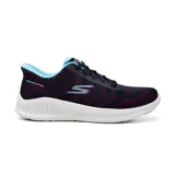 Championes deportivos Skechers Hands Free Slip-ins Go Walk Now Khloe para mujer, color negro con detalles en fucsia y celeste. Capellada de malla con cordones elásticos, plantilla Skechers Air-Cooled Goga Mat y amortiguación ULTRALIGERA.