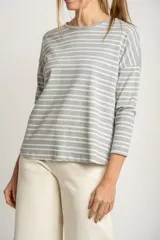Sweater oversize gris con rayas horizontales blancas, de tejido suave y mangas largas.