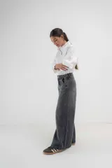 Pantalón de jean azul de pierna ancha y tiro medio, con cinco bolsillos y pespuntes a contratono.