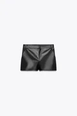 Shorts negros de tiro alto confeccionados en cuero sintético, con bolsillos delanteros y cierre frontal con cremallera y ganchos metálicos.