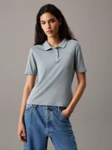 Chomba celeste de punto de algodón suave, corte slim, cuello de chomba, tapeta de tres botones, mangas cortas y bordado de Calvin Klein en la misma gama de tonos en el pecho.