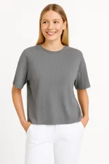 Remera gris de poliéster, de manga corta, corte holgado y cuello redondo.