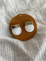 Aros con base de bronce y nácar redondo, con pasador de bronce y tapones de silicona.
