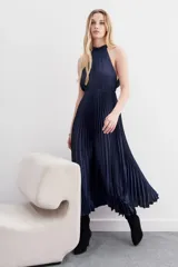 Vestido largo azul de escote halter, con volados en el cuello, elástico en la cintura y falda plisada.