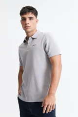 Chomba gris con textura tipo waffle, corte regular y logo bordado en el pecho.