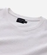 Remera masculina blanca de manga corta y cuello redondo, confeccionada en tejido waffle texturizado.