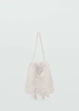 Bolso blanco de crochet con apliques florales y doble asa corta.