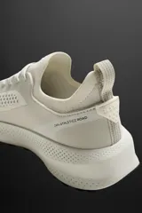 Zapatilla deportiva color crudo para uso diario y carreras ligeras. Parte superior de tejido de punto transpirable con puntera y talón recubiertos de material Shield Protect Max. Ajuste con cordones, tirador trasero y plantilla OrthoLite® extraíble. Entresuela con tecnología Spume Foam V3 y suela de goma.