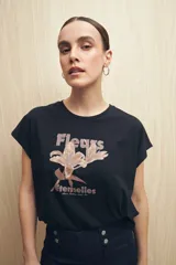 Remera negra de manga corta con estampado floral y tipográfico en tonos marrones.