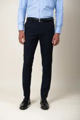Pantalón de vestir azul marino, de corte slim fit, con bolsillos laterales y traseros. Se ajusta a la cintura con cinturón de cuero negro.