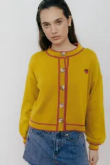 Cárdigan amarillo de punto con botones frontales, bordes tejidos en contraste color fucsia y bordado de limón en el pecho.