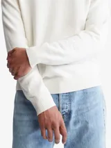 Sweater color crema de cuello redondo y corte clásico. Tiene un pequeño logo de la marca bordado en el pecho.