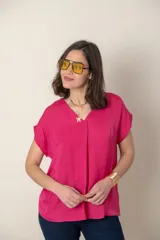 Blusa fucsia de seda con escote en V y mangas cortas.