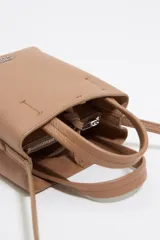 Bolso mini de piel vacuna color negro, con estructura blanda y formato vertical. Tiene doble asa corta, correa larga regulable, cierre con cinta, logo metálico BIMBA Y LOLA, acabados metálicos, bolsillo interior con cierre de cremallera e interior con logo grabado.