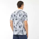 Remera polo de piqué de algodón blanca con estampado de hojas en azul y cuello blanco.