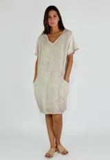 Vestido corto color beige de lino y algodón, con escote en V y mangas cortas.