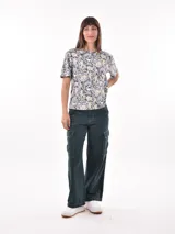 Pantalón cargo de mujer color beige claro, tiro medio/alto, corte ancho y recto, con bolsillos laterales tipo parche en las piernas.