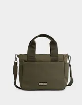 Cartera tipo tote color verde militar, de tela deportiva engomada, con doble asa corta y correa larga regulable y desmontable. Tiene cierre superior, bolsillos laterales y tag de goma con el logo de la marca.