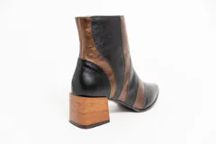 Botas cortas de cuero negro y bronce, con punta fina, cierre lateral y taco de madera.