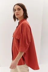 Sobrecamisa celeste de corte recto, con cuello mao, mangas 3/4 con puños y cierre frontal con botones. Tiene dos bolsillos de parche en el pecho.