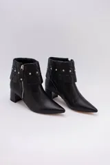 Botas cortas de cuero negro con taco cuadrado y punta fina. Presentan cuello caído capitoneado con apliques brillantes y cierre lateral con cremallera.
