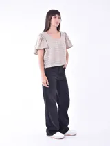 Blusa color blanco con mangas cortas abullonadas y calado con pequeños orificios.