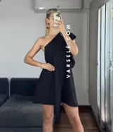 Vestido corto color verde lima, con escote asimétrico a un hombro, volado en el hombro y elástico en el borde superior.