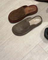 Zueco tipo mule de cuero color marrón, con plataforma gruesa y detalle de ribete color bordó en la base de la capellada.