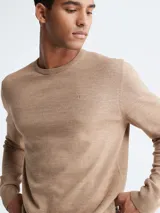 Sweater de lana merino color beige, con cuello redondo y logo bordado en el pecho.