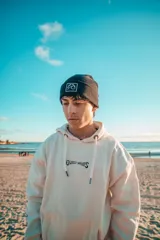 Buzo hoodie color natural con estampado en la espalda de una ola y el texto "Glassy Waves".