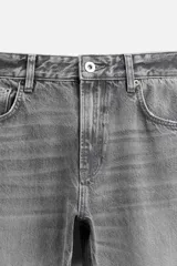 Pantalón de jean negro con efecto lavado, corte flare, cinco bolsillos, cierre frontal con cremallera y botón, y bajo con acabado irregular.