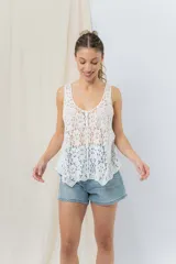 Musculosa blanca de encaje calado con diseño floral, escote en V y breteles anchos.