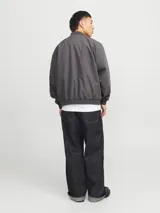 Campera bomber liviana color gris, de manga larga con cuello baseball y fit cómodo. Diseño con cierre frontal de cremallera, bolsillos delanteros funcionales y puños de canalé.