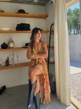 Vestido largo con estampado floral, escote halter y corte asimétrico con volados.