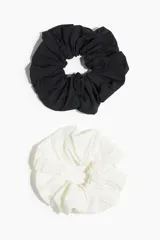 Pack de dos scrunchies elásticos de nylon, uno negro y otro blanco.