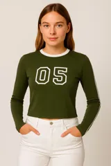 Remera manga larga verde militar de algodón, corte al cuerpo, con cuello redondo blanco, estampado con el número 05 en el pecho y dos líneas blancas en las mangas.