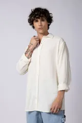 Camisa color arena de lino, manga larga, con cuello clásico y corte holgado.