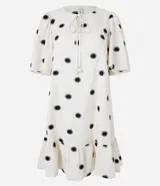 Vestido corto evasé color crema con estampado de soles negros, cuello redondo con lazo, mangas cortas y bajo con volantes.