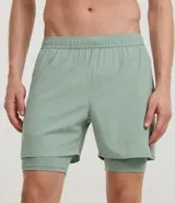 Short deportivo para hombre, color gris claro, con short de compresión negro incorporado. Presenta un pequeño logo bordado en la pierna derecha.