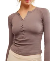 Remera de ajuste ceñido en color gris, con escote pronunciado abotonado y agujeros para el pulgar.