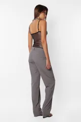 Pantalón de vestir gris, de corte recto y tiro medio. Presenta detalle de falsa cintura con presillas y cinto tira incluido.