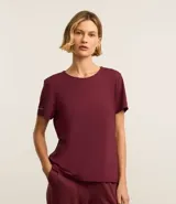 Remera deportiva blanca texturizada, con cuello redondo, manga corta, detalle reflectante y pliegue en la espalda.