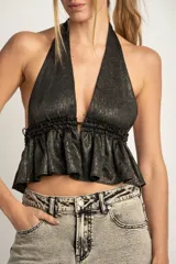 Top negro con brillo dorado, estilo halter con escote pronunciado y volados en la parte inferior.