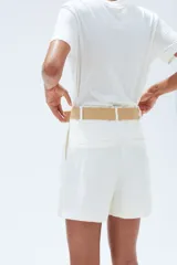Short blanco de tiro alto con pinzas, bolsillos laterales y traseros. Incluye cinturón trenzado con hebilla redonda.