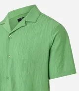 Camisa de hombre color verde claro, corte slim, de manga corta y cuello inglés. Confeccionada en viscosa texturizada.