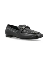Mocasín de cuero negro con apliques de tachas plateadas y hebilla metálica.