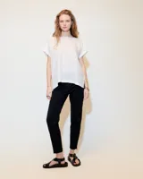 Top blanco de lino melange, de silueta relajada, con cuello bote, espalda con costura en el centro y tajos en los laterales del ruedo.