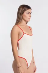 Malla enteriza color crudo con ribetes rojos, breteles finos y espalda baja.