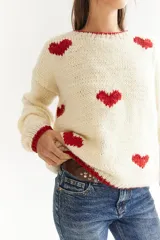 Sweater color crema de lana merino, tejido a mano, con corazones rojos.