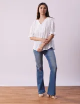 Blusa blanca calada con escote en V, mangas cortas con hombros fruncidos y puños elastizados.